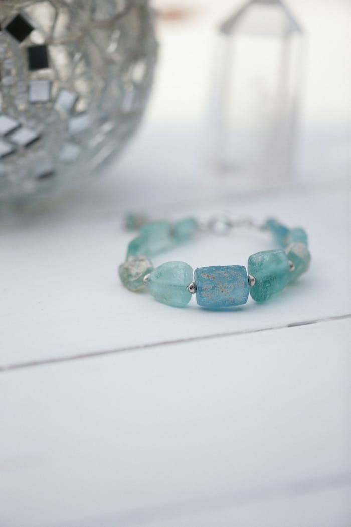 Close-up of a blue gemstone bracelet displayed on a white surface, exuding elegance and style.